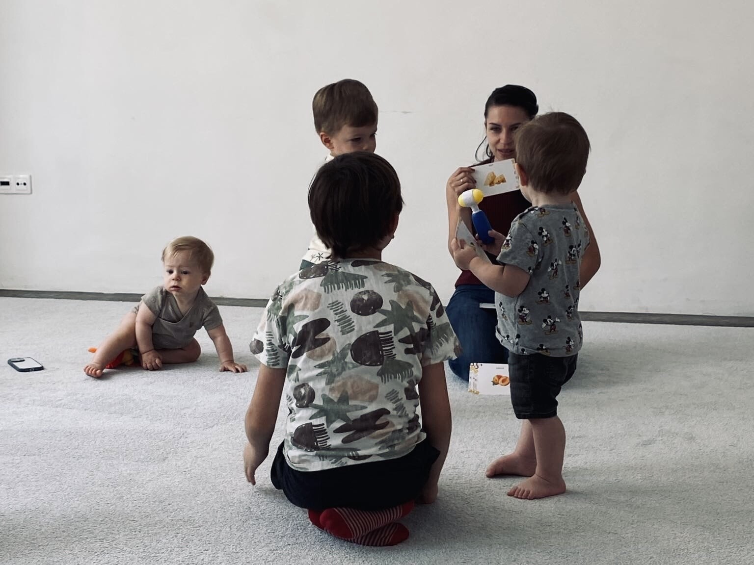 4 baba a Csemete Jelek babajelbesz&eacute;d foglalkoz&aacute;son, mik&ouml;zben Lejla a babajelbesz&eacute;d k&aacute;rty&aacute;t mutatja.